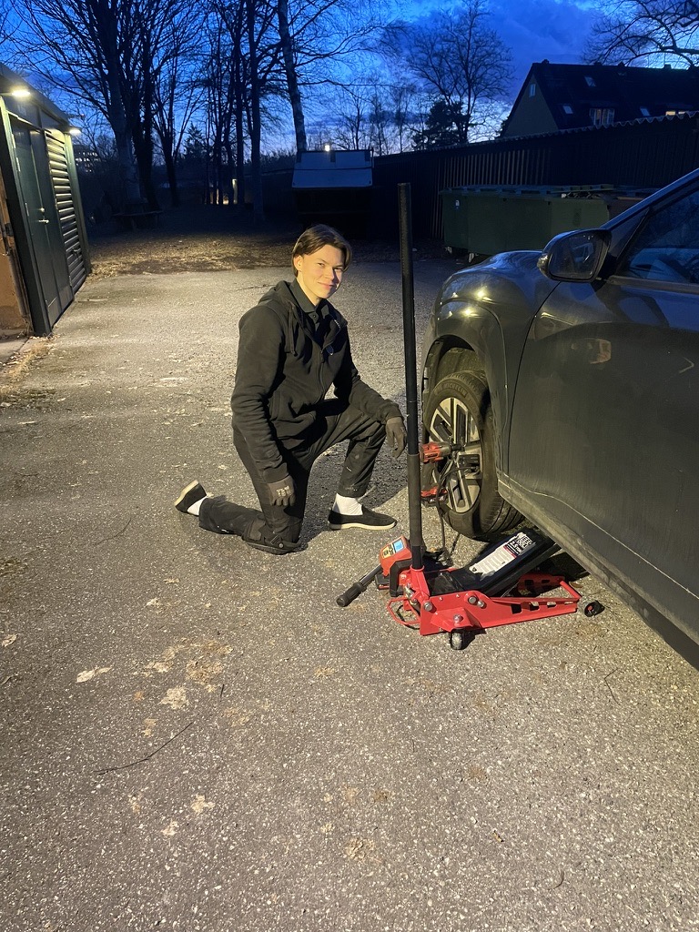 Theodor Wahlberg byter däck på en kunds uppfart i skymningen